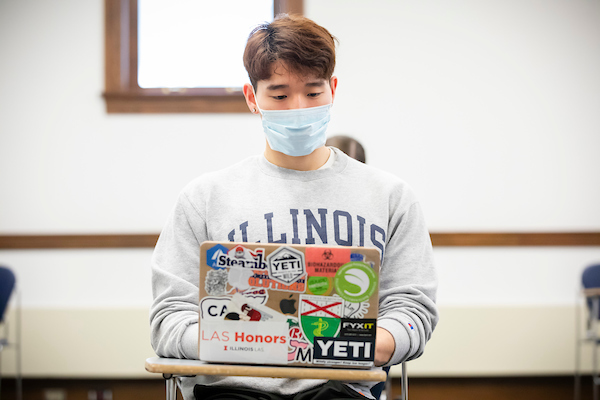 Illinois student working on his laptop inside the classroom